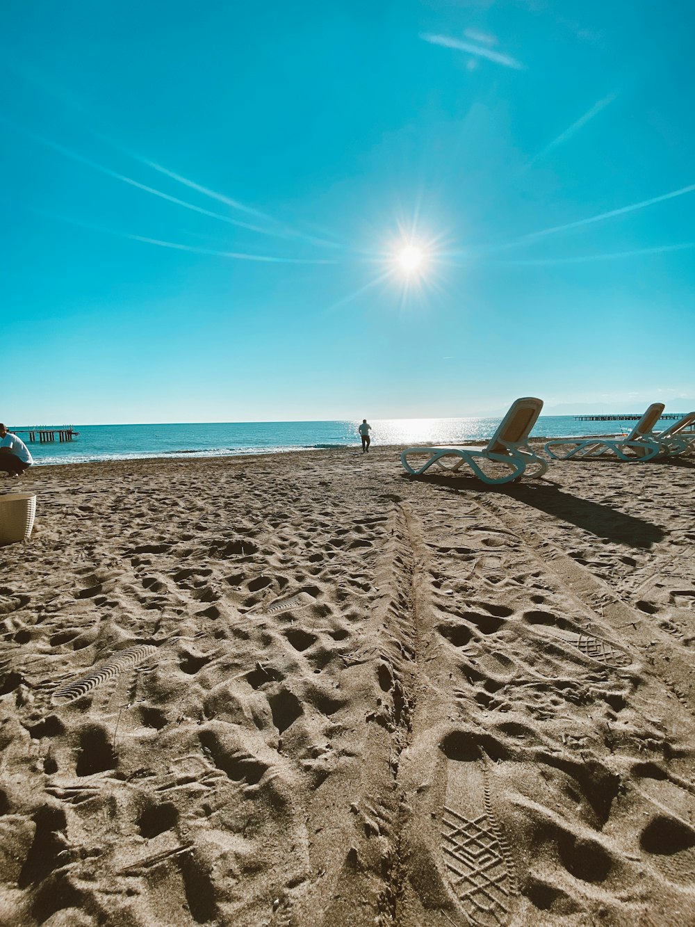 white and blue beach chair on white sand during daytime