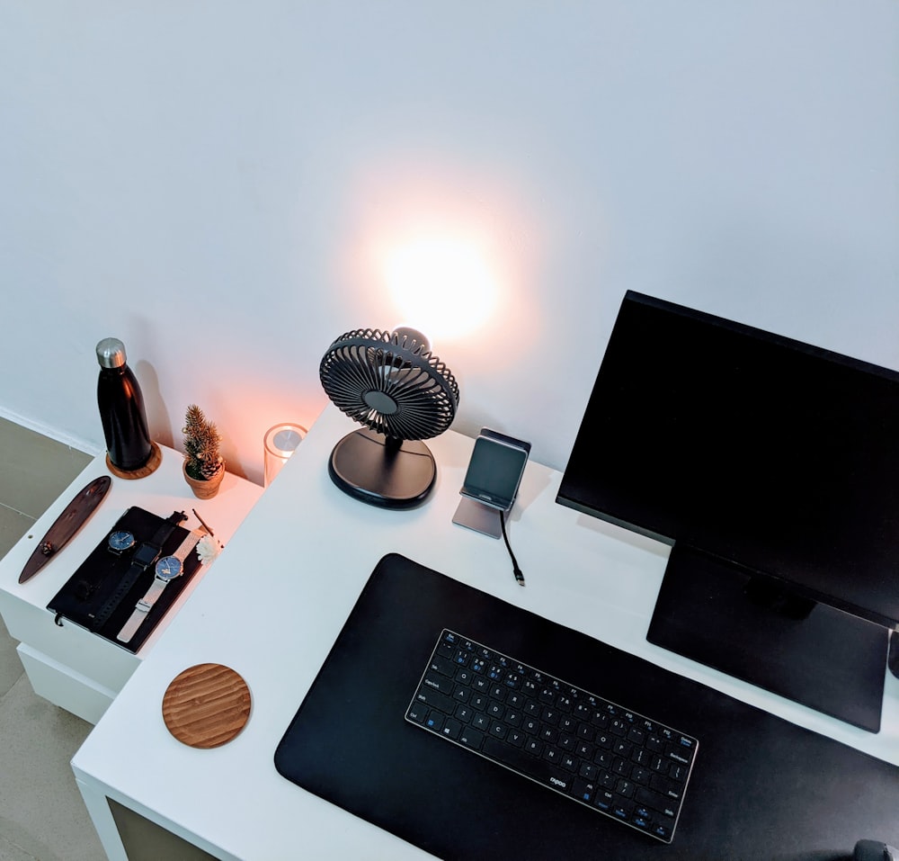 a desk with a computer and a lamp on it