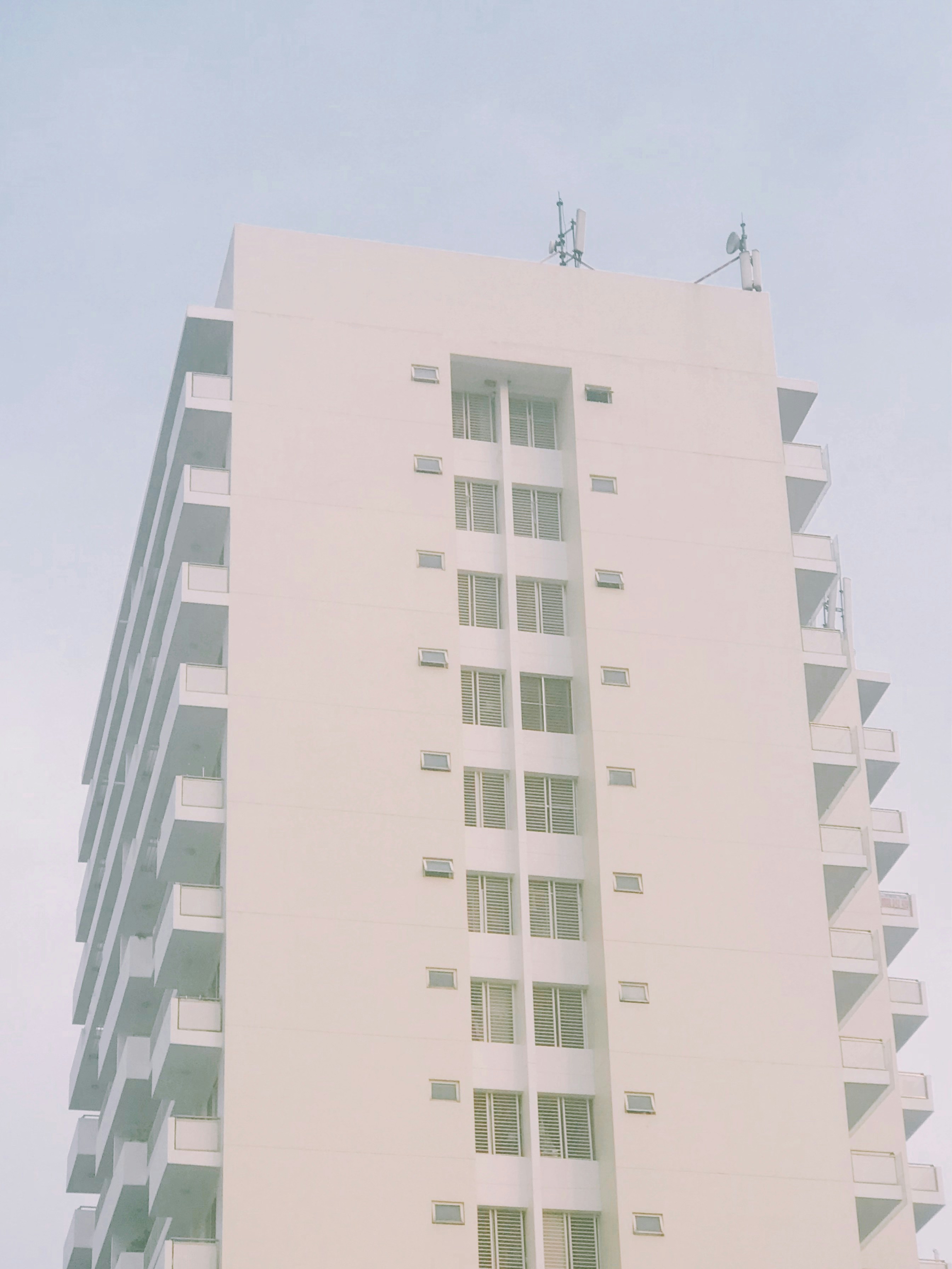 a tall white building sitting next to a parking meter