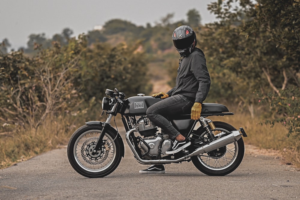 man in black jacket riding motorcycle on road during daytime