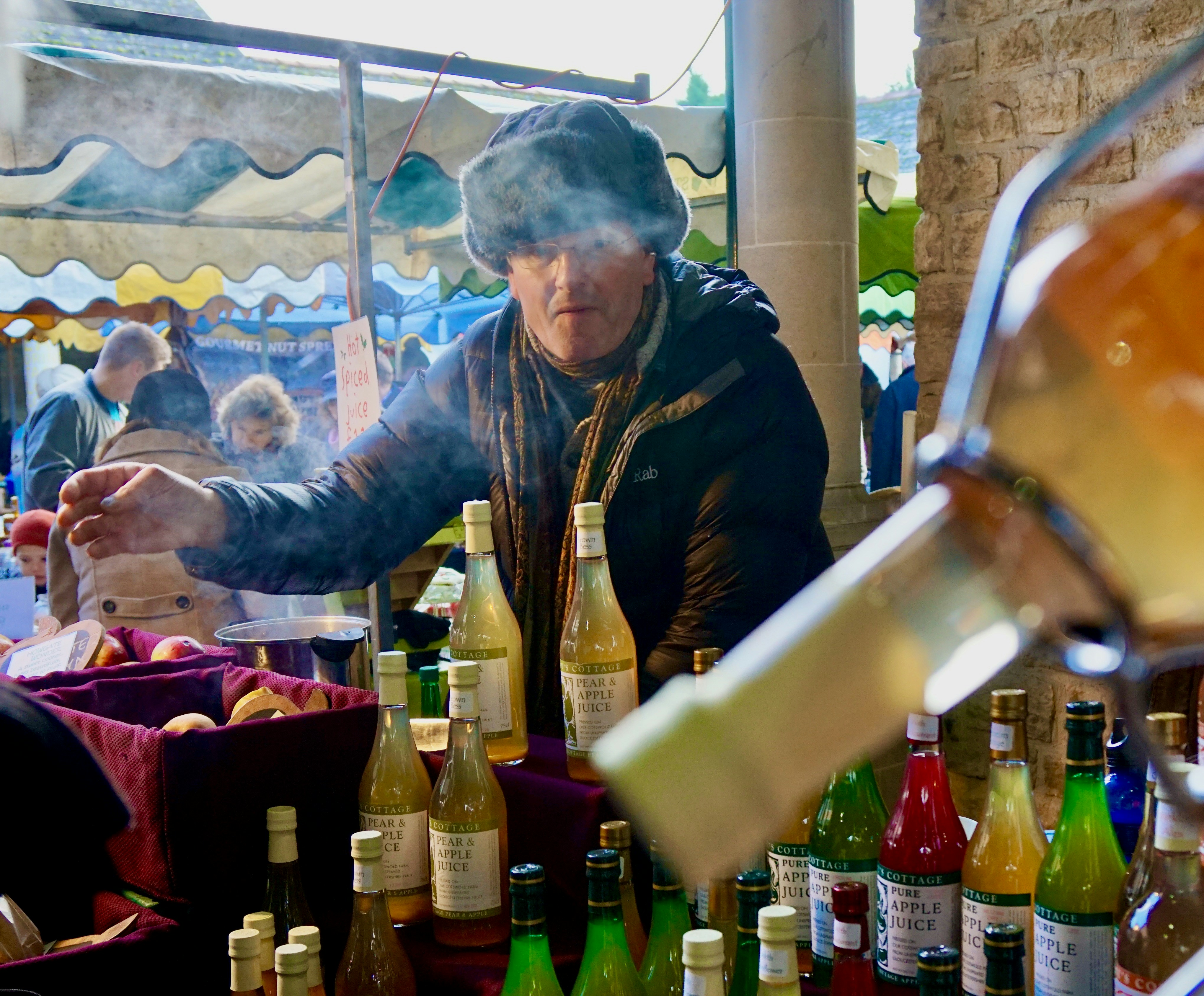 man in brown jacket holding clear glass bottle
