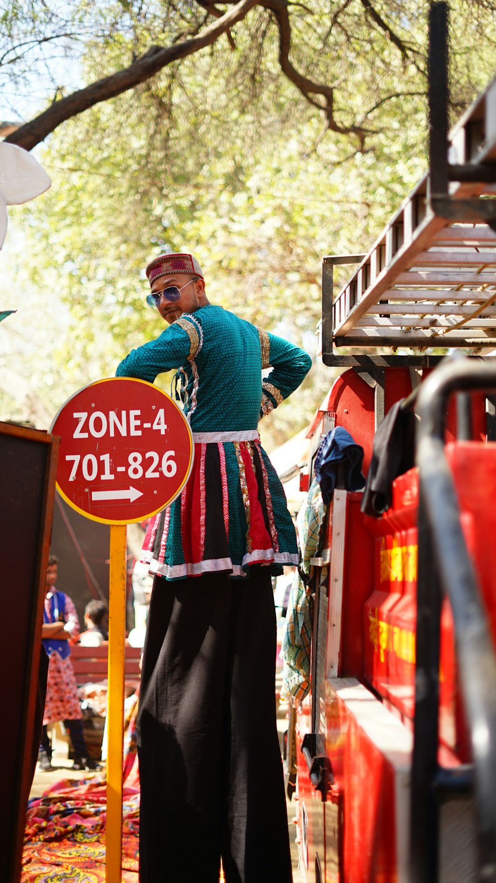 man in blue long sleeve shirt and black pants standing near red and white signage