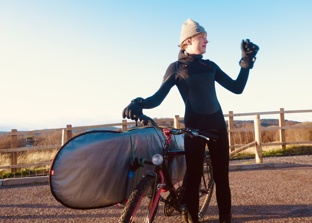 woman in black jacket riding on red bicycle during daytime