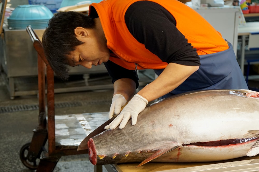 woman in orange t-shirt holding fish