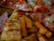 Slices of pizza with pepperoni and melted cheese are visible alongside crispy sweet potato fries. The thin crust pizza features a generous serving of toppings, including pepperoni and ham.