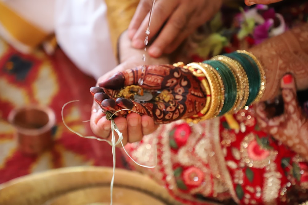 person holding silver and gold bracelet