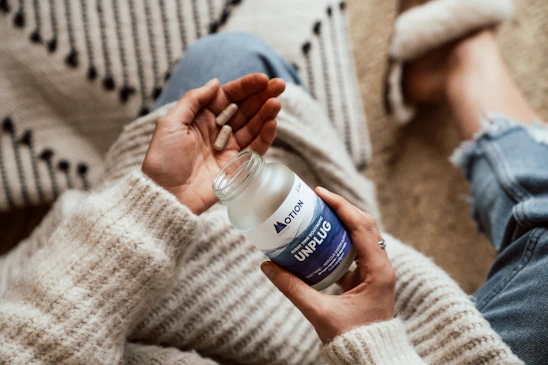 A cozy home setting with a person using a smart health device, surrounded by wellness products.