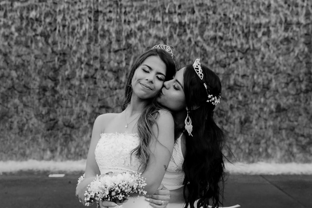 grayscale photo of woman in wedding dress beside woman in wedding dress