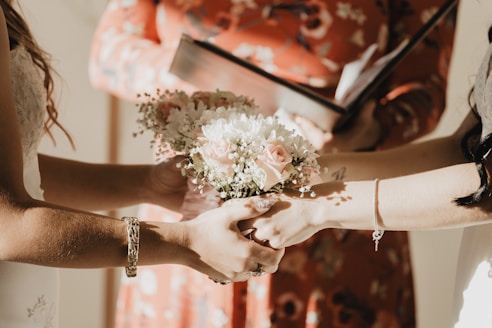 person holding white flower bouquet