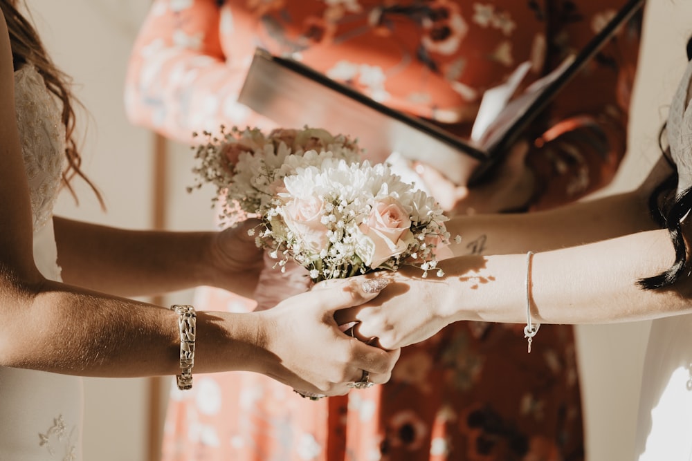 person holding white flower bouquet