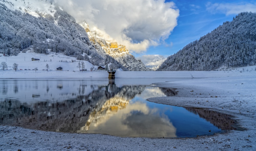 montanha coberta de neve perto do corpo de água durante o dia