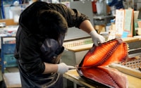 person in black long sleeve shirt holding brown and white fish