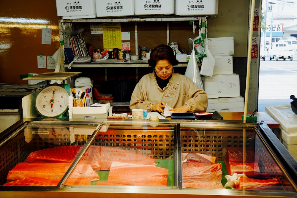 woman in white long sleeve shirt standing in front of food stall