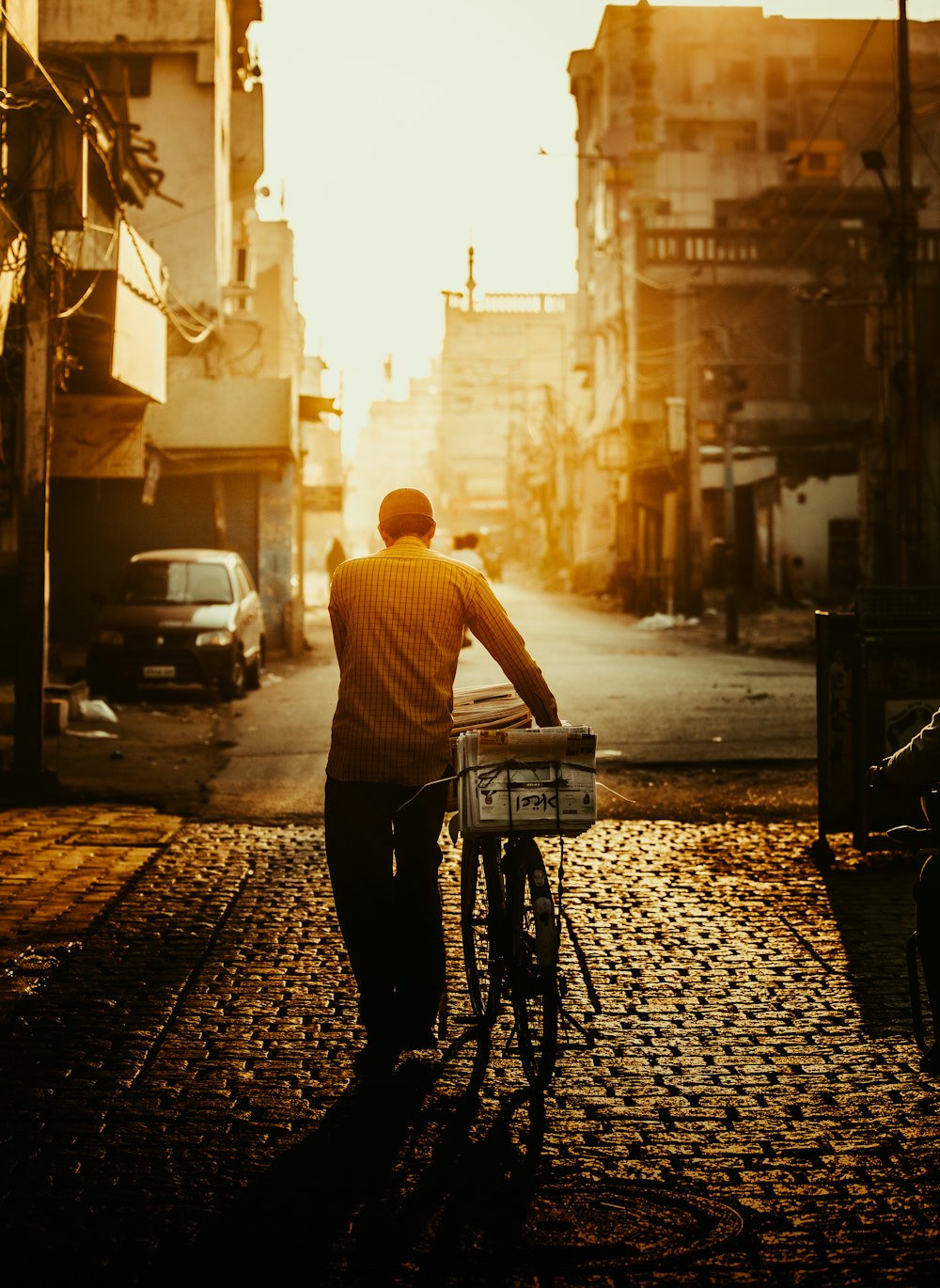 man in white shirt riding bicycle on street during daytime