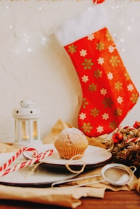 A cozy scene featuring a Christmas stocking filled with small festive gifts against a red and gold backdrop.