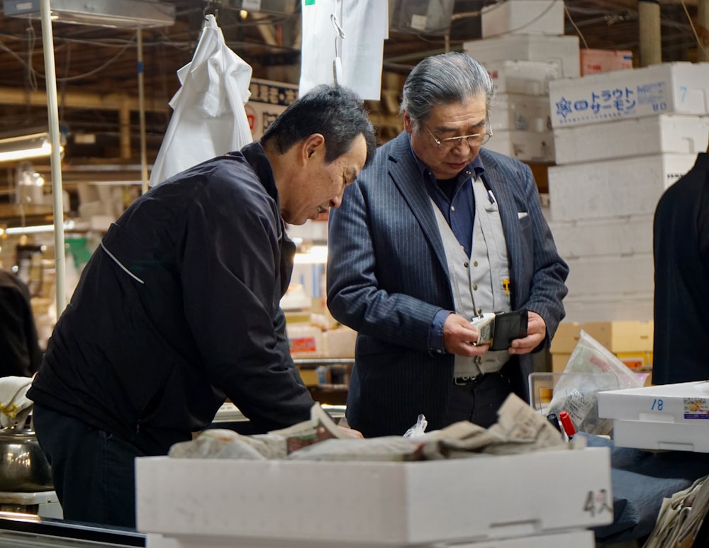 man in black jacket holding white box