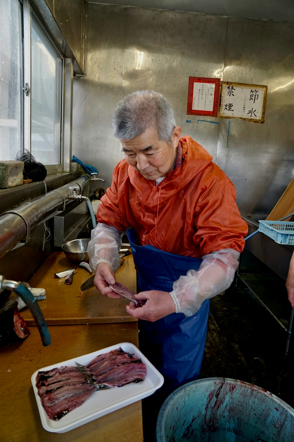 man in orange jacket holding white plastic gloves