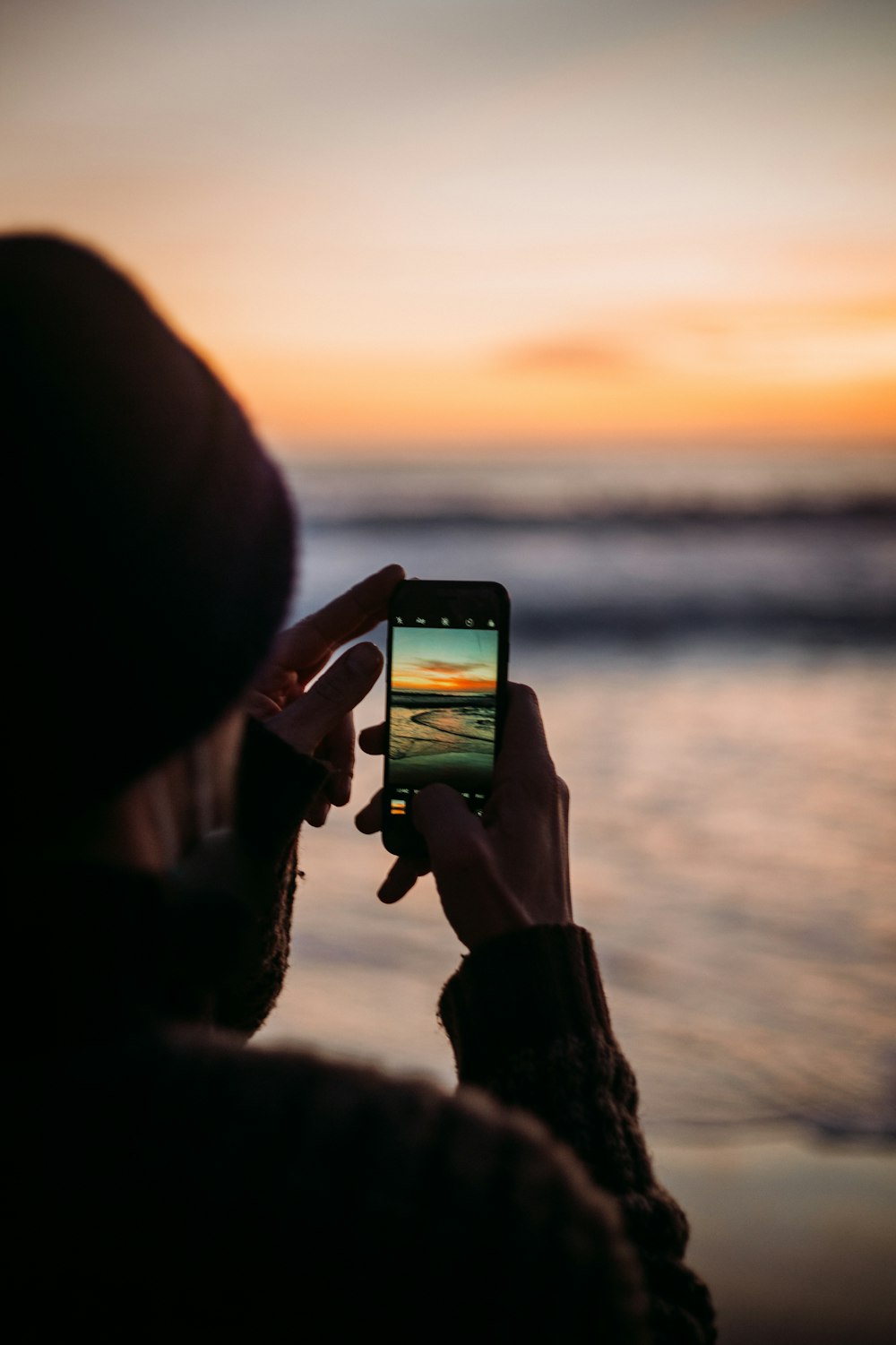 person holding black smartphone during sunset