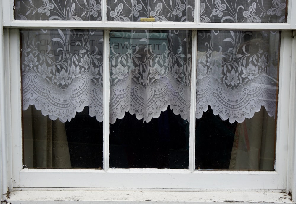 cortina de ventana floral blanca en la ventana