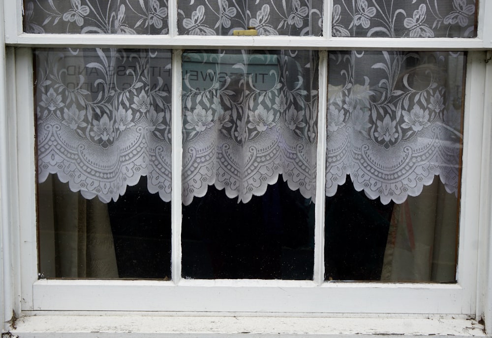 white floral window curtain on window