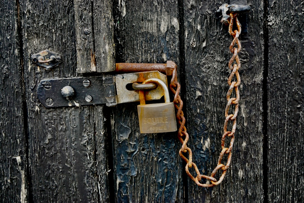 brown padlock on black wooden door