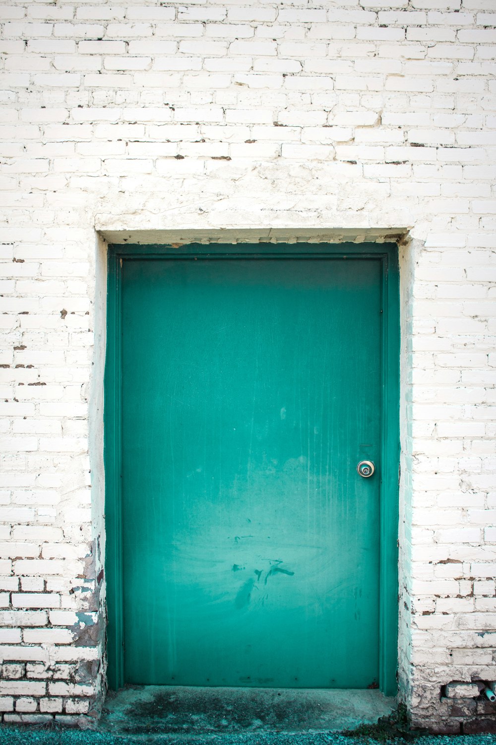blue wooden door on white brick wall