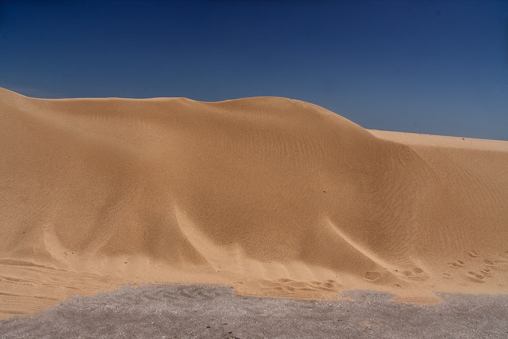 brown sand dunes under blue sky during daytime