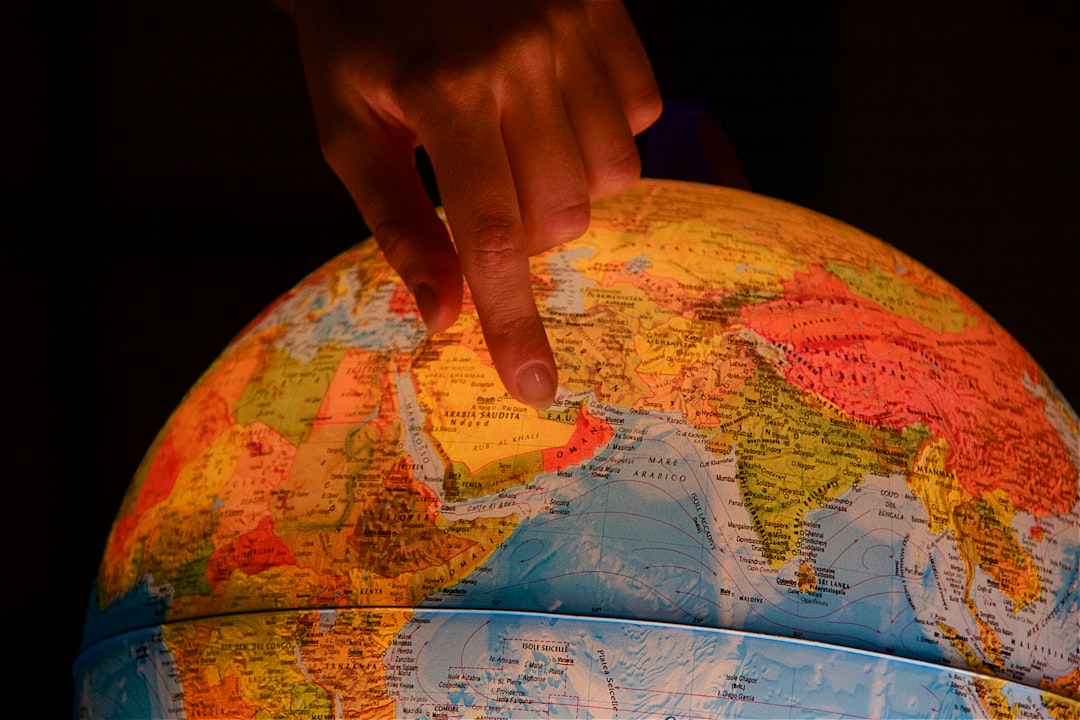 person holding world map globe