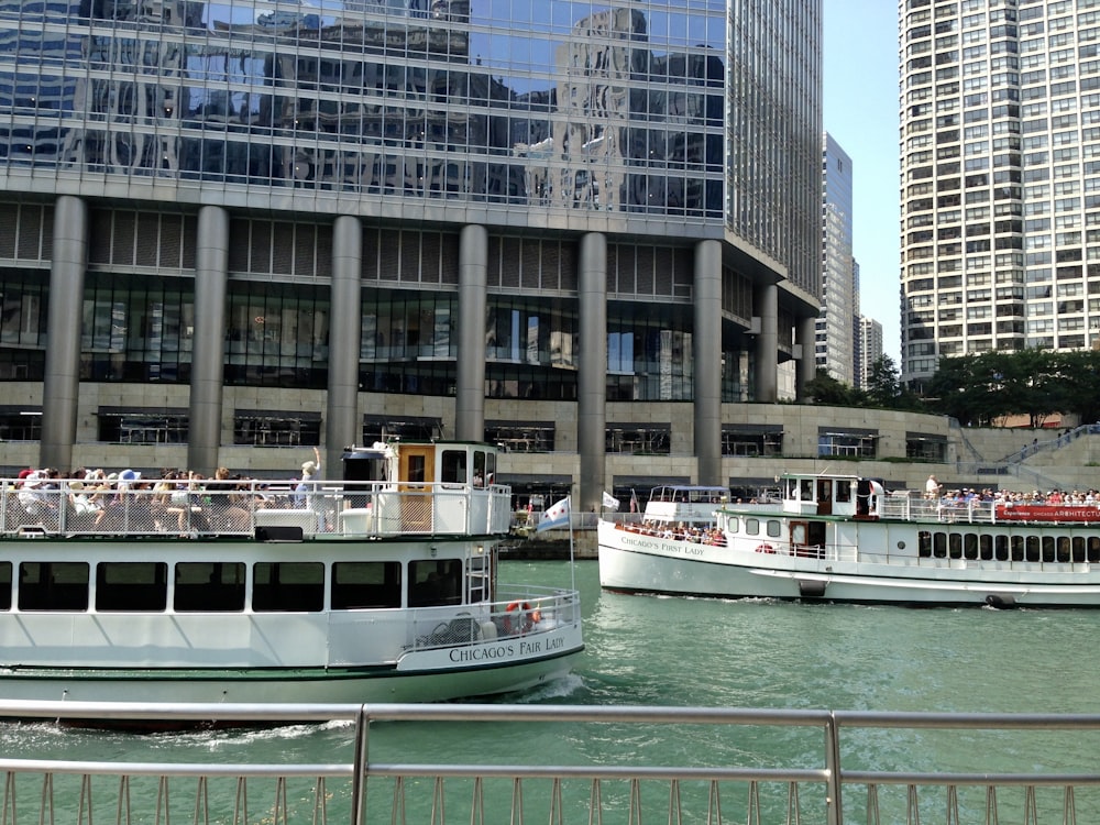 white and black boat on body of water near city buildings during daytime