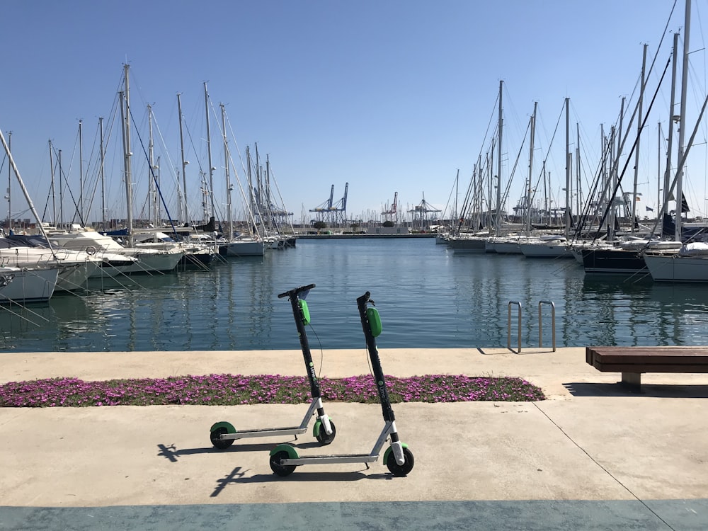 black and green kick scooter beside body of water during daytime