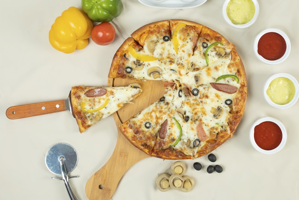흰색 세라믹 접시에 치즈와 녹색 피망을 곁들인 피자