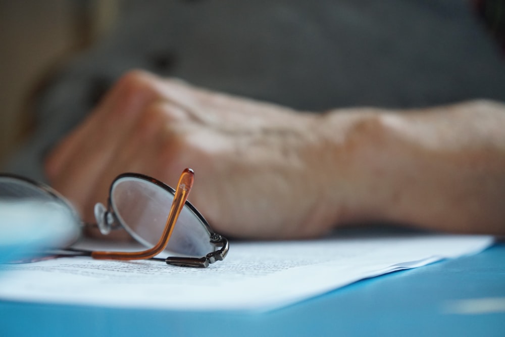 brown framed eyeglasses on blue textile