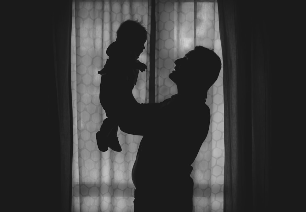 silhouette of man standing near window