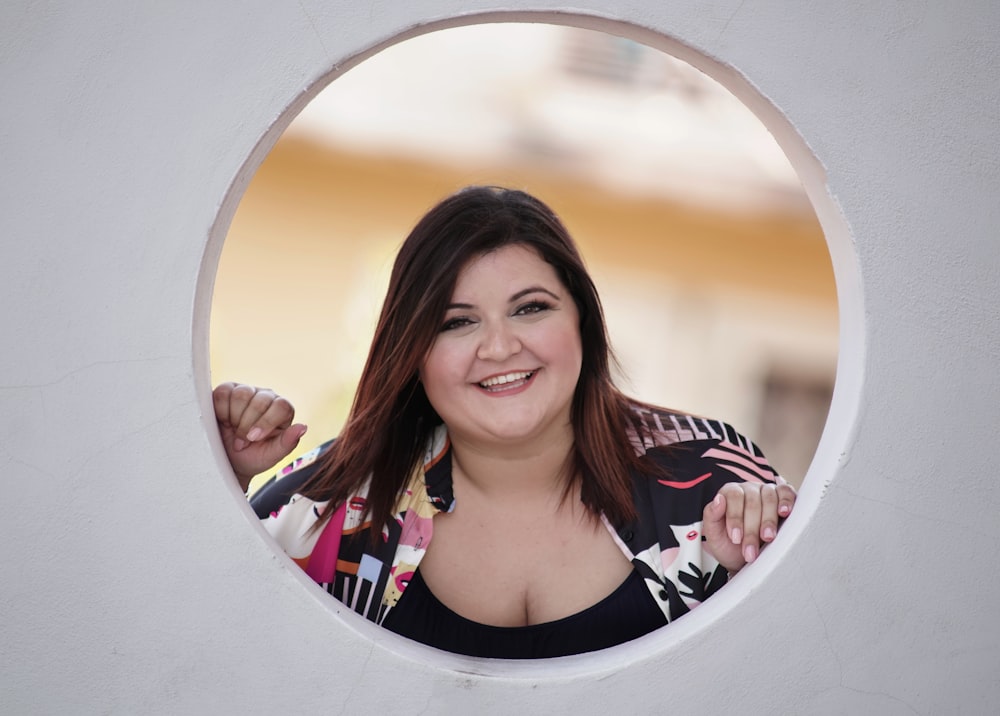 woman in black white and red floral shirt smiling