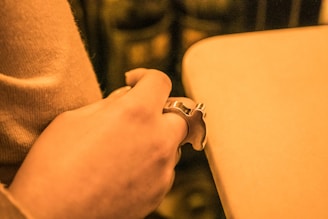 Close-up of a sleek, custom metal keychain resting on a wooden table with soft natural light highlighting its polished finish.