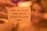 A hand is holding a small card with a motivational question printed on it against a blurred background. The lighting is warm and creates a cozy ambiance.