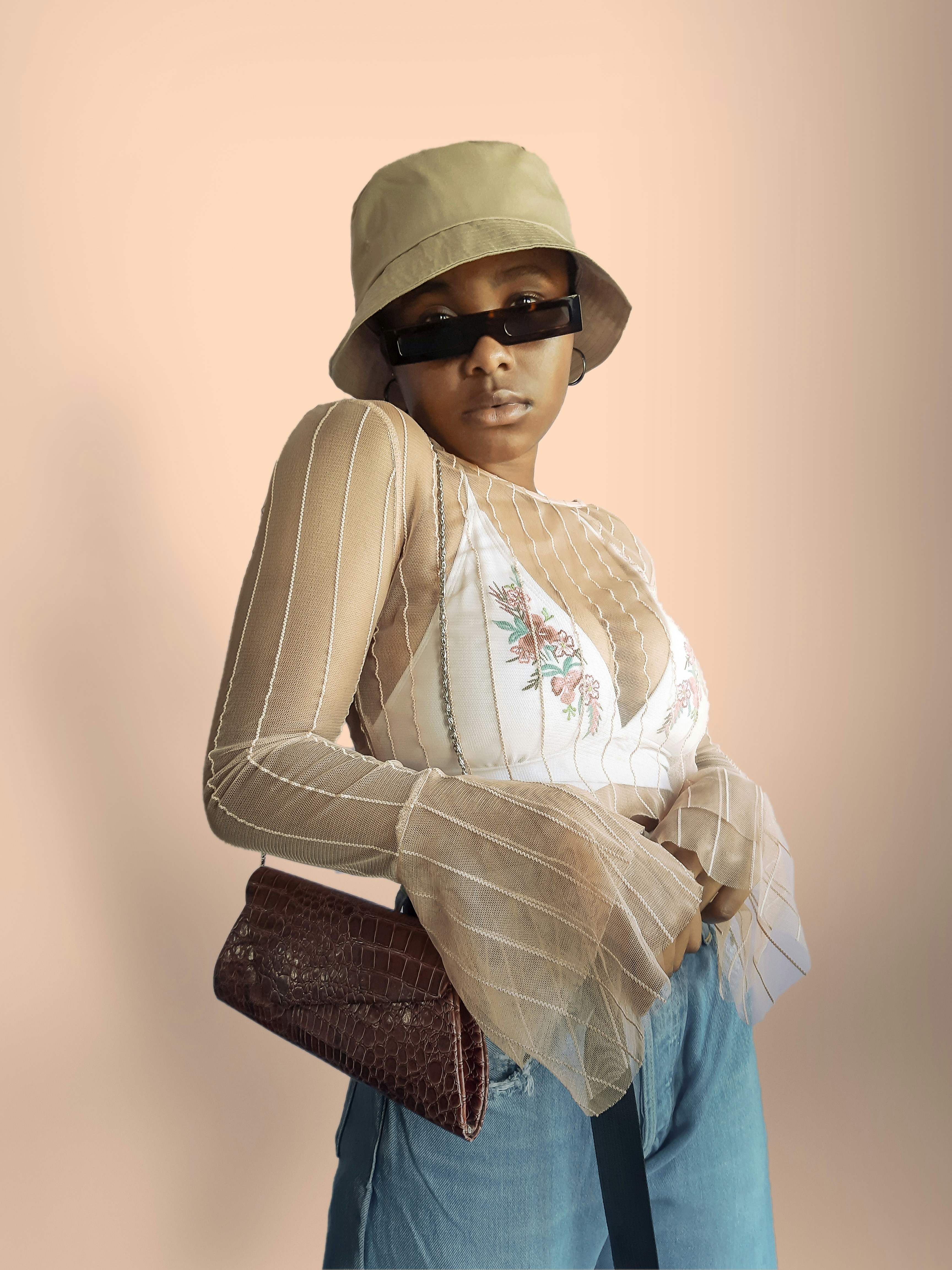 woman in white long sleeve shirt and blue denim jeans wearing brown hat