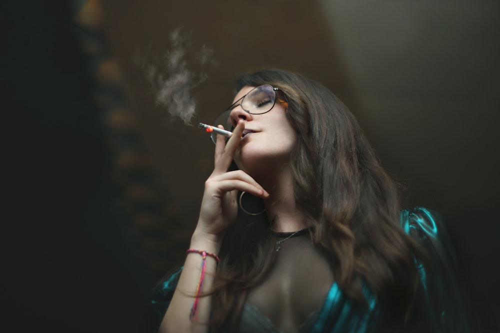 woman in black framed eyeglasses smoking cigarette