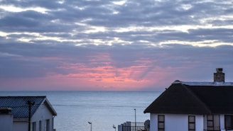 A cozy seaside mobile home with a bright sunset in the background.