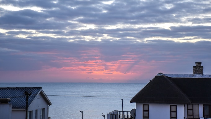 A cozy seaside mobile home with a bright sunset in the background.