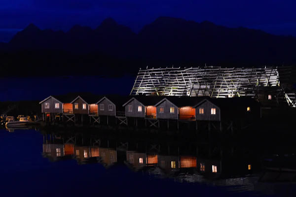 Lit waterside house on a clear winter night in Svolvær, northern Norway