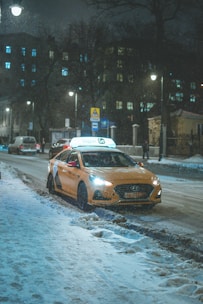 yellow sedan on road during snow