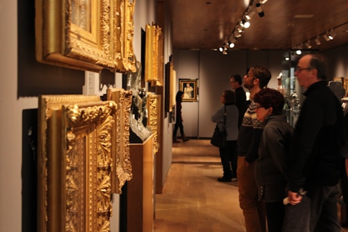 Visitors admiring framed botanical artworks in a museum gallery.