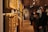 Visitors admiring detailed Mughal miniature paintings displayed in a well-lit gallery space.