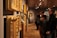 Visitors admiring detailed Mughal miniature paintings displayed in a well-lit gallery space.
