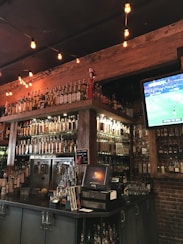 black flat screen tv turned on near brown wooden shelf