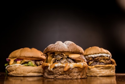 Vibrant photo of a variety of Monki Burguer signature burgers arranged on a rustic wooden table.