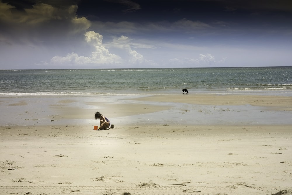woman in white shirt sitting on beach during daytime