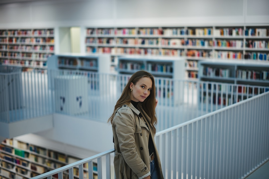 woman in beige coat standing near white wooden railings