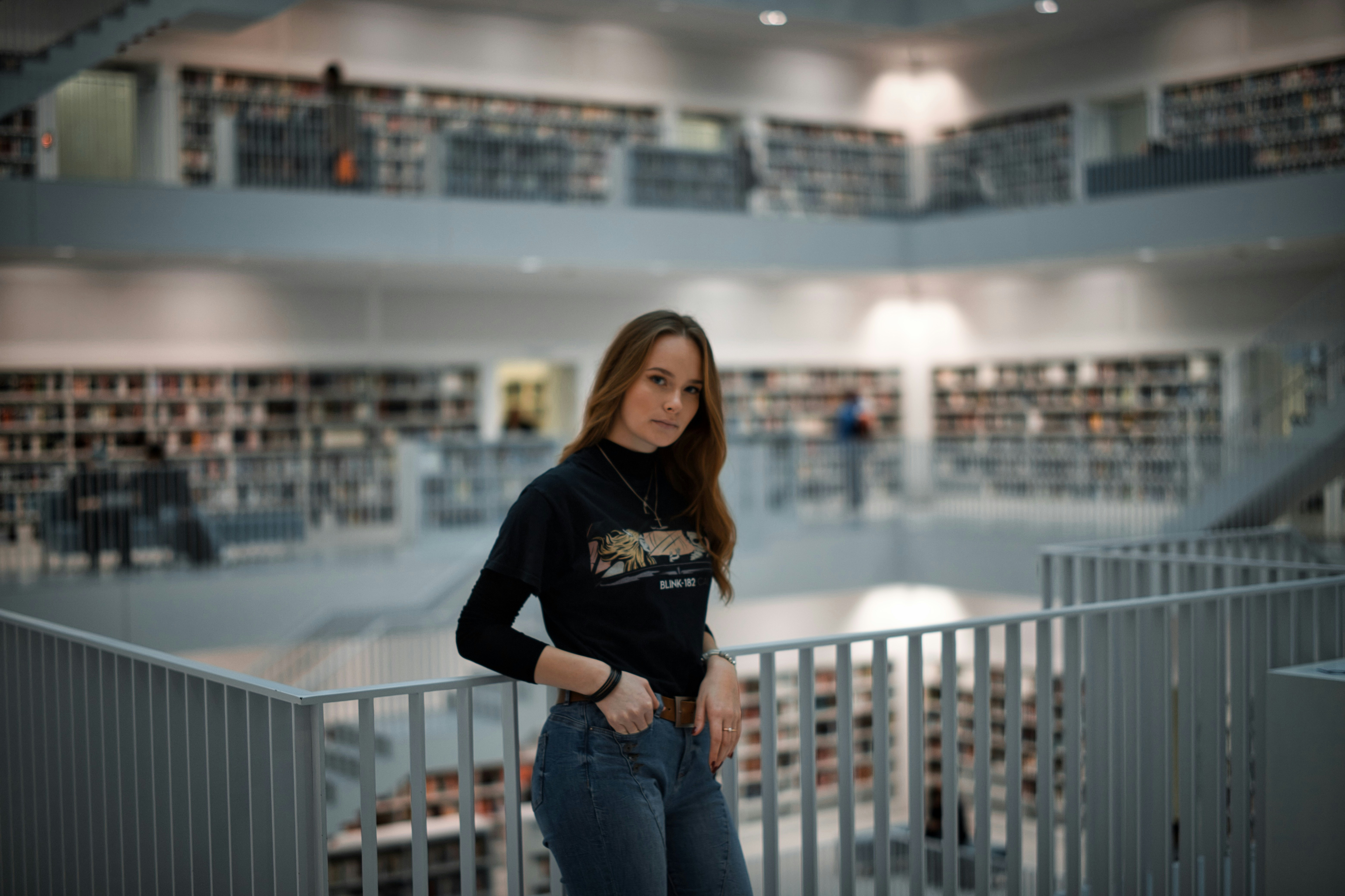 woman in black long sleeve shirt and blue denim jeans standing on balcony during daytime